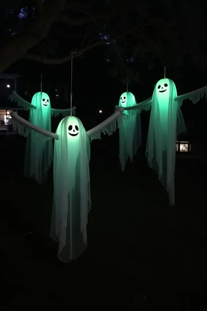 Floating tree ghosts glowing with cheesecloth drapes, swaying with glowing faces in the night.